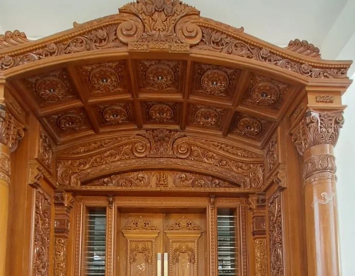 Carved teak arch with relief panels and scrolling foliage